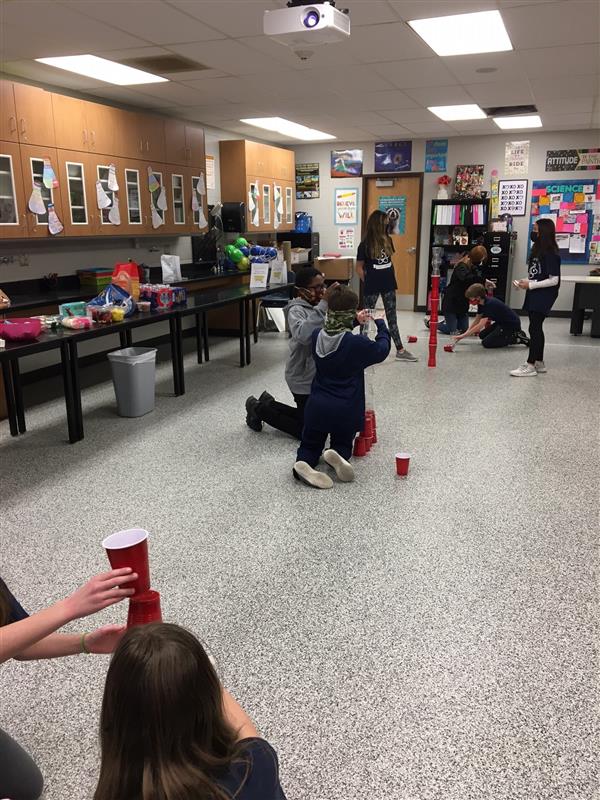 Students play a cup-stacking game